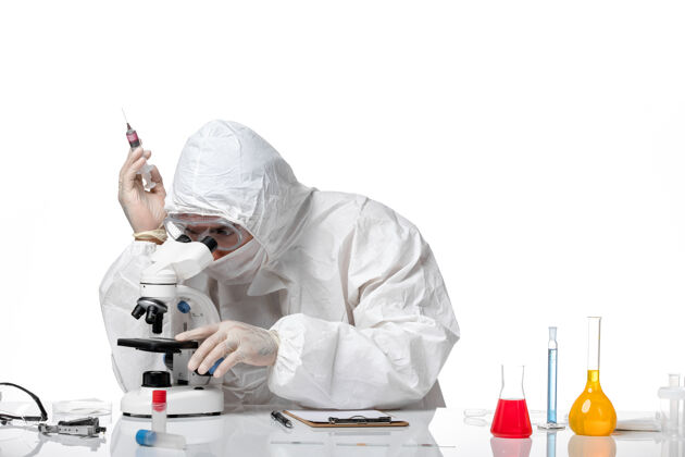 化学正面图：男医生穿着防护服 戴着面罩 在空白处使用显微镜专业视图防护