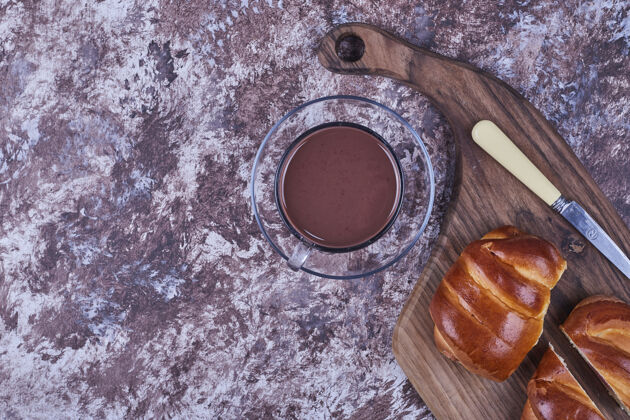 玻璃在木板上放一个甜面包和一杯热巧克力高质量的照片小吃美味糕点