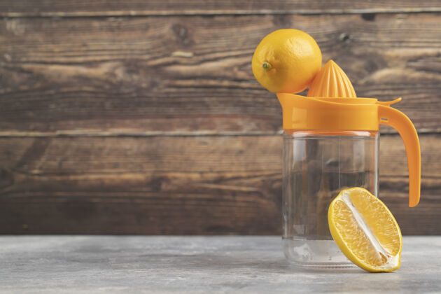水壶一个空的玻璃罐 木头上有一个完整的柠檬一个大理石罐子