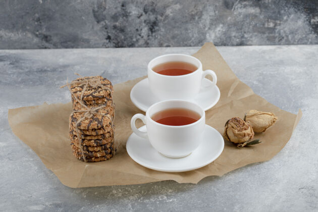 茶美味的带种子的饼干和巧克力 还有一杯放在大理石上的茶烘焙甜点美味