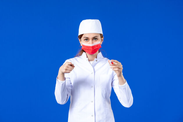 医院正面图：身穿白色医疗服的女护士 戴着红色面罩 手上拿着蓝色针剂医疗男性手