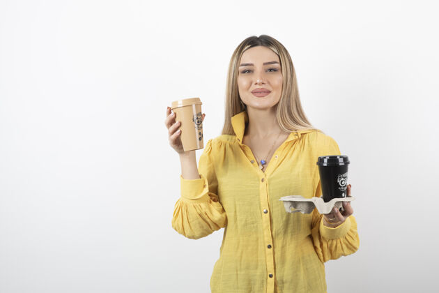 肖像一张年轻女子的肖像 她拿着几杯咖啡摆姿势女人年轻姿势