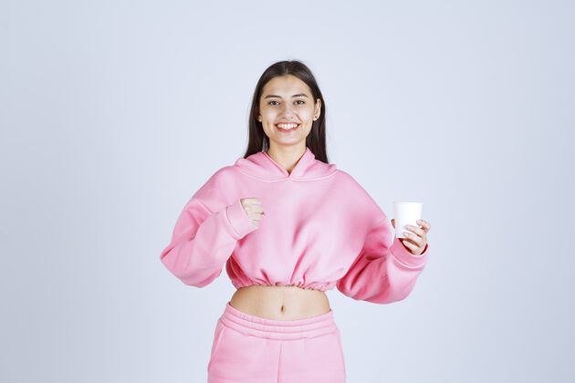 运动穿着粉色睡衣的女孩拿着咖啡杯 伸出拳头积极女性休闲