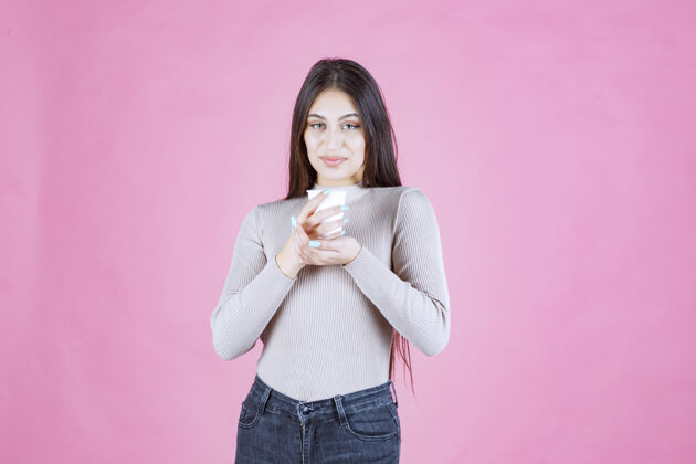 休闲女孩拿着一个白色的一次性咖啡杯 推销它或闻到新鲜的咖啡人姿势成人