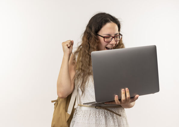 抱快乐的年轻漂亮的女学生戴着眼镜 背着包拿着笔记本电脑举起拳头女学生笔记本电脑提高