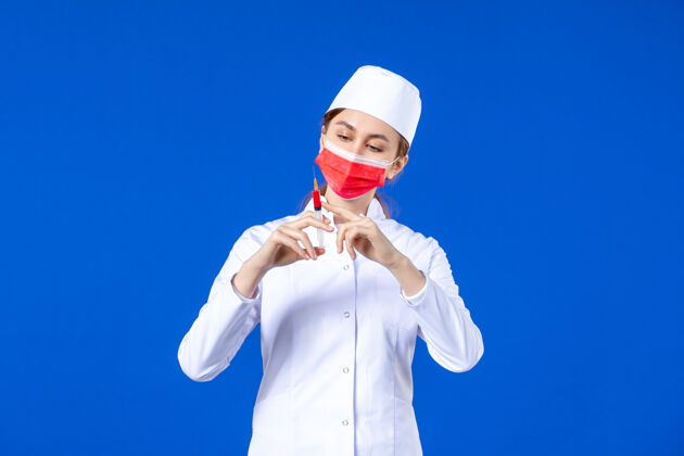 流行病正面图：身穿白色医疗服的女护士 戴着红色面罩 手上拿着蓝色针剂人注射面罩