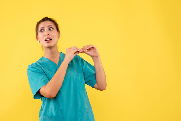 女医生前视图黄色背景上穿着医用衬衫的女医生视图一成人
