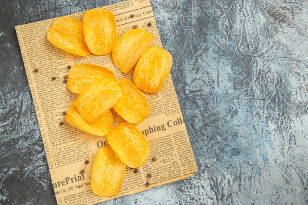 配料灰色桌子上报纸上美味的自制薯条俯视图自制薯片柑橘食物