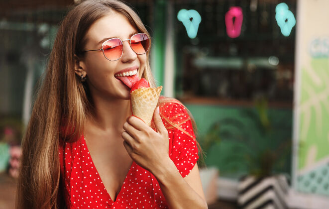 街头快乐的年轻女子在暑假吃糖果冰淇淋都市太阳镜
