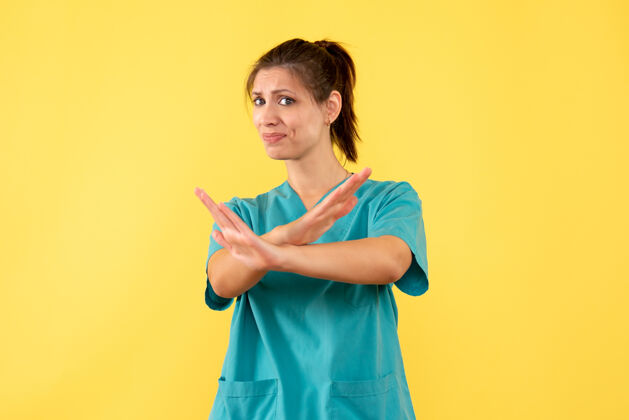 女医生前视图黄色背景上穿着医用衬衫的女医生衬衫医疗病毒