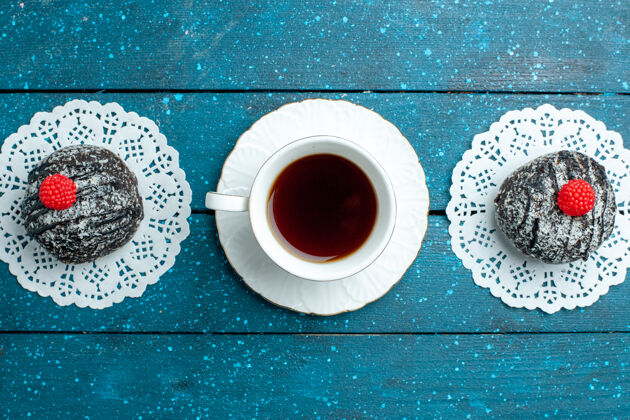 巧克力俯瞰美味的巧克力球和一杯茶在蓝色的乡村书桌上茶蛋糕饼干饼干甜顶部杯子蛋糕