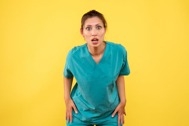 视图前视图黄色背景上穿着医用衬衫的女医生病毒医疗黄色