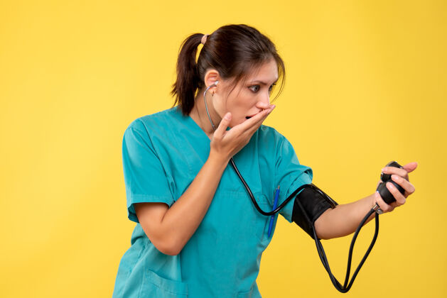 医疗前视图穿着医用衬衫的女医生正在检查黄色背景上的压力女医生人健康