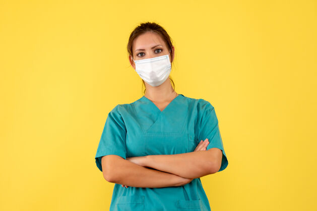 医疗前视图黄色背景上穿着医用衬衫和面罩的女医生人黄色正面