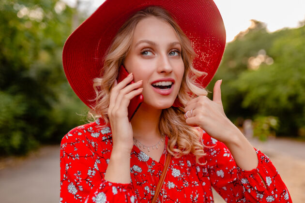 女性迷人的时尚金发微笑的妇女在稻草红色帽子和衬衫夏季时尚服装画像在电话交谈积极的姿态情感时尚优雅女士