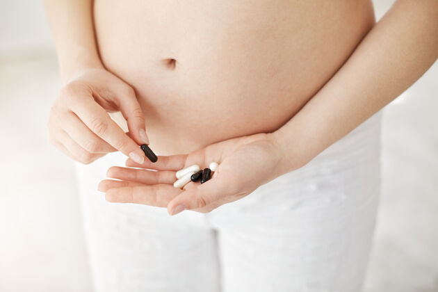 年轻人孕妇手持处方药 出现恶心或过敏的特写镜头健康怀孕理念休闲休息房子