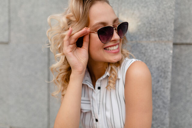 时尚城市街道上一位年轻迷人的时尚金发女郎的特写肖像 穿着夏季时尚的连衣裙 戴着太阳镜肖像优雅积极