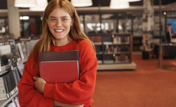 肖像红发女读书 捧着书在书店里笑着大学教科书阅读