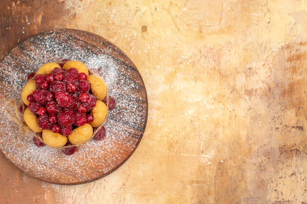 饮食混合色桌上木制砧板上自制水果软蛋糕的水平视图可食用水果早餐碗