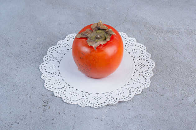 配料多汁的柿子放在大理石背景的小桌布上水果饮食健康