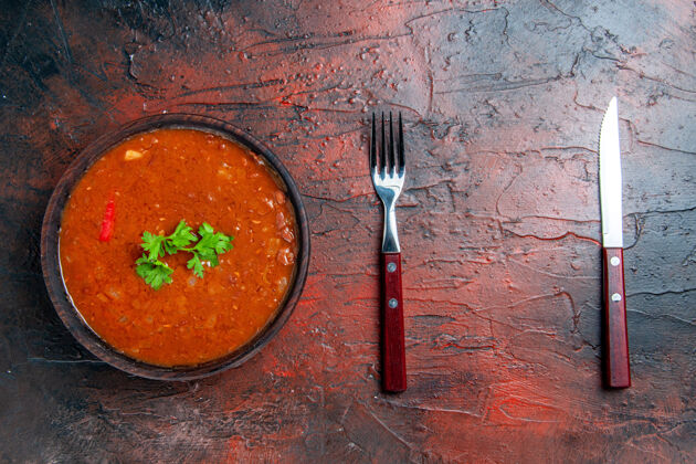 勺子经典的番茄汤放在棕色的碗里 勺子放在五颜六色的桌子上容器翻斗车厨具