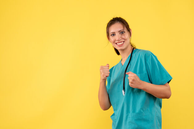 情绪正面图黄色背景上穿着医疗衬衫微笑的女医生听诊器成人视图