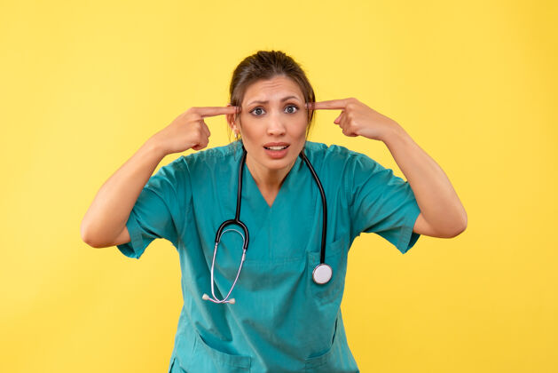 医疗前视图黄色背景上穿着医用衬衫的女医生病毒情绪药