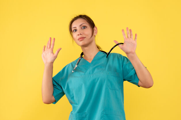 视图前视图黄色背景上穿着医用衬衫的女医生前面人健康