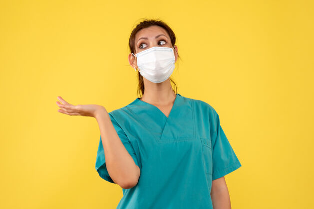 衬衫前视图黄色背景上穿着医用衬衫和面罩的女医生黄色健康医生