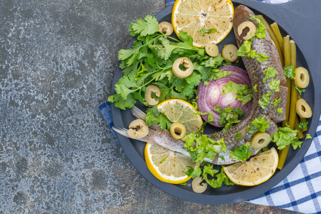 有机把鱼和蔬菜放在木锅上 放在茶巾上海洋小吃橄榄