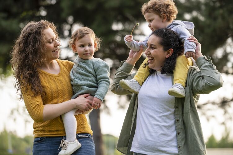 家庭快乐的同性恋母亲在公园外和孩子们在一起同性恋家庭水平孩子