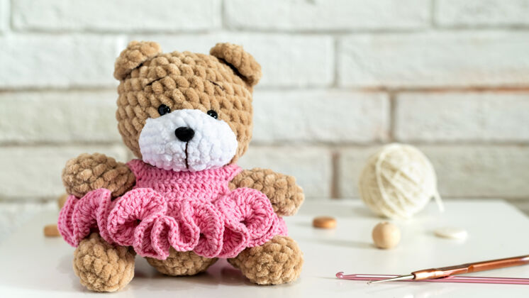 童年桌上摆着针织设备编织的泰迪熊可爱有趣童话