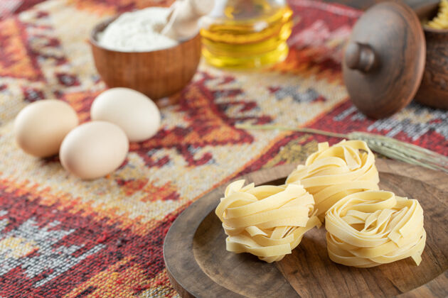 健康用鸡蛋和面粉在木板上做意大利面油木材费图西尼