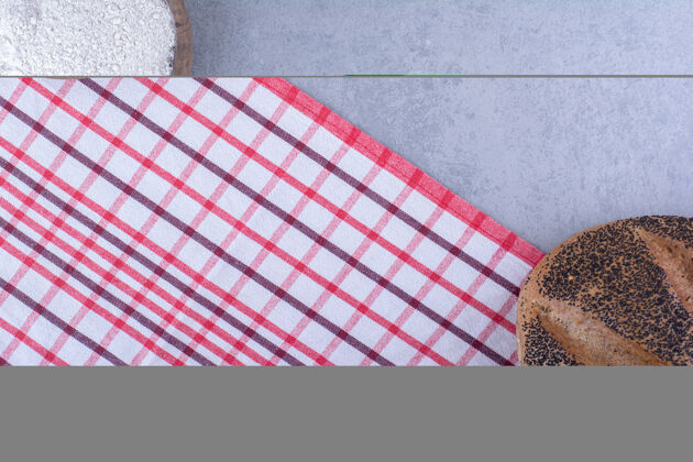 酵母面粉和涂了芝麻的面包在大理石表面相对对齐面团烘焙食品口味