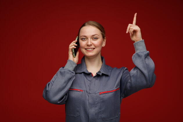 波多微笑着的年轻金发女工程师穿着制服对着电话指着上制服女年轻