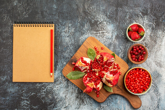 美食黑色背景上红色水果的石榴片俯视图一餐食品肉