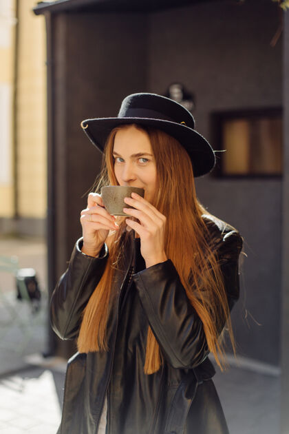 食物在咖啡馆喝咖啡的漂亮女孩坐着城市太阳镜
