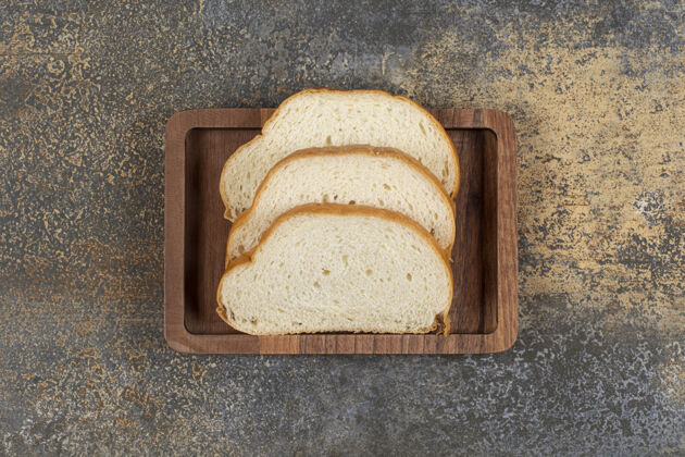 营养美味的白面包片放在木盘上面包房切片早餐