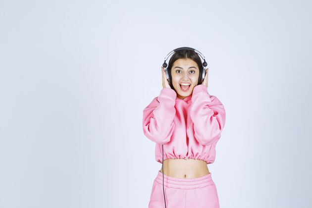 人穿着粉色睡衣的女孩听着耳机玩得很开心人体模型成人欢乐
