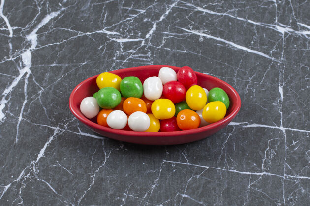 糖果一堆五颜六色的糖果放在红碗里糖果圆的食物