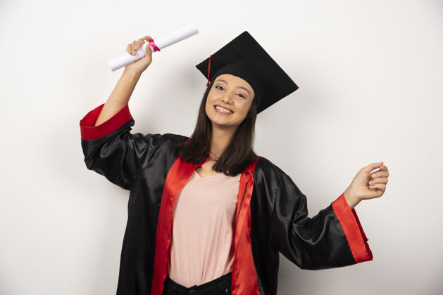 学生大学毕业生穿长袍站在白色背景上帽子毕业学术