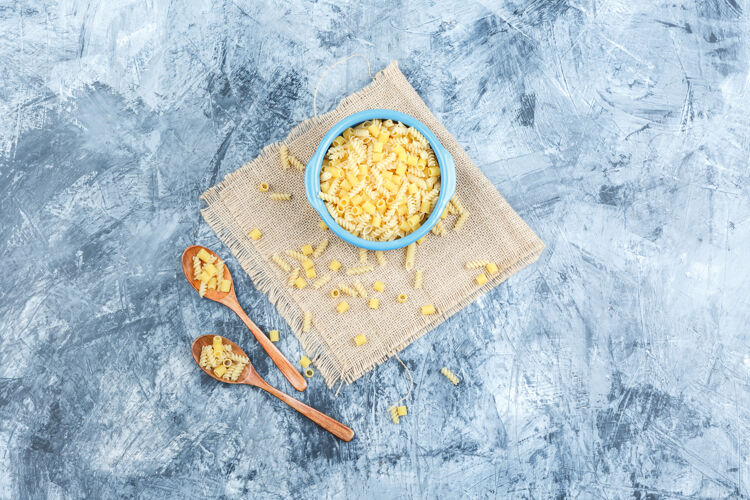 博洛尼亚生面食放在碗里 木勺放在灰泥上 布袋背景顶视图奶酪石膏素食者