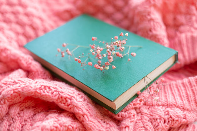 花一件粉色温暖的针织毛衣上有干花的绿皮书春天的心情成人知识