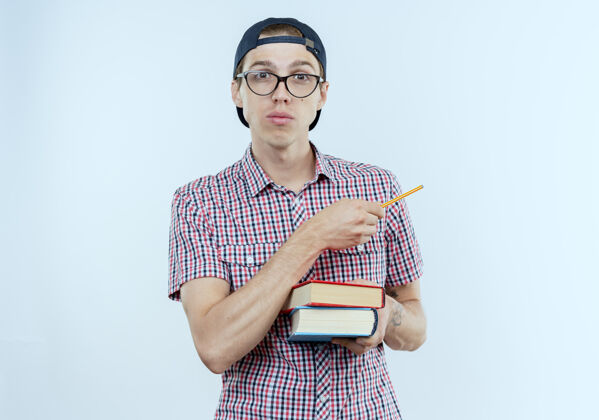 年轻人戴着眼镜和帽子的年轻学生男孩拿着书和笔指着身边戴青少年壁板