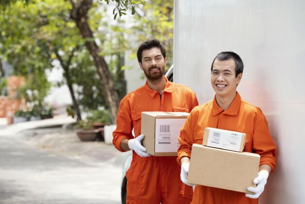 快乐年轻的送货员在搬运各种包裹箱业务盒子微笑