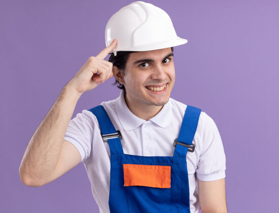 目录年轻的建筑工人身着建筑制服 头戴安全帽 表情自信 面带微笑 食指指着太阳穴专注于一项任务站立表情男人