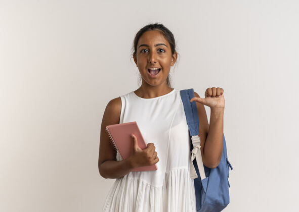 自己快乐的小女生背着书包拿着笔记本指着自己背包快乐年轻人