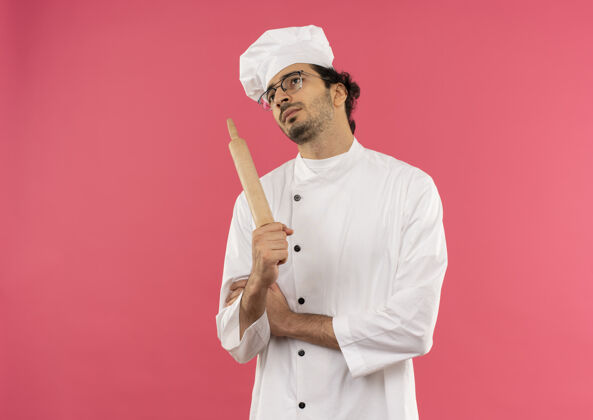 男抬头望着想着年轻的男厨师 穿着厨师制服 戴着眼镜 手里拿着滚锅平底锅向上制服