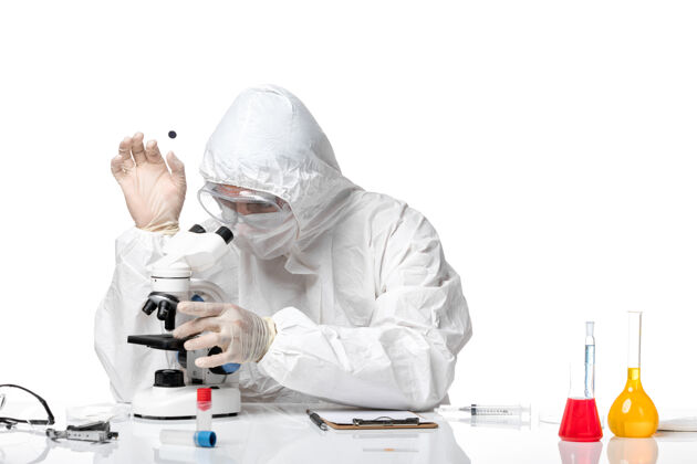 套装正面图：男医生穿着防护服 戴着面罩 因为科维德在空白处用显微镜工作防护显微镜大流行