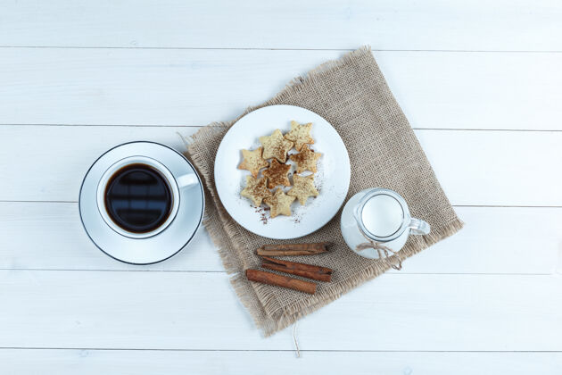 棒顶视图咖啡杯饼干 肉桂棒 牛奶在木制和布袋的背景餐厅鸡蛋果酱